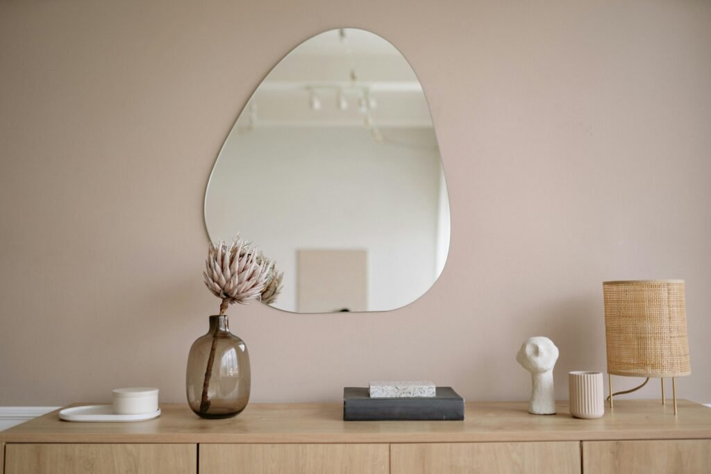 Stylish minimalist interior featuring a mirror, decorative vase, and lamp.